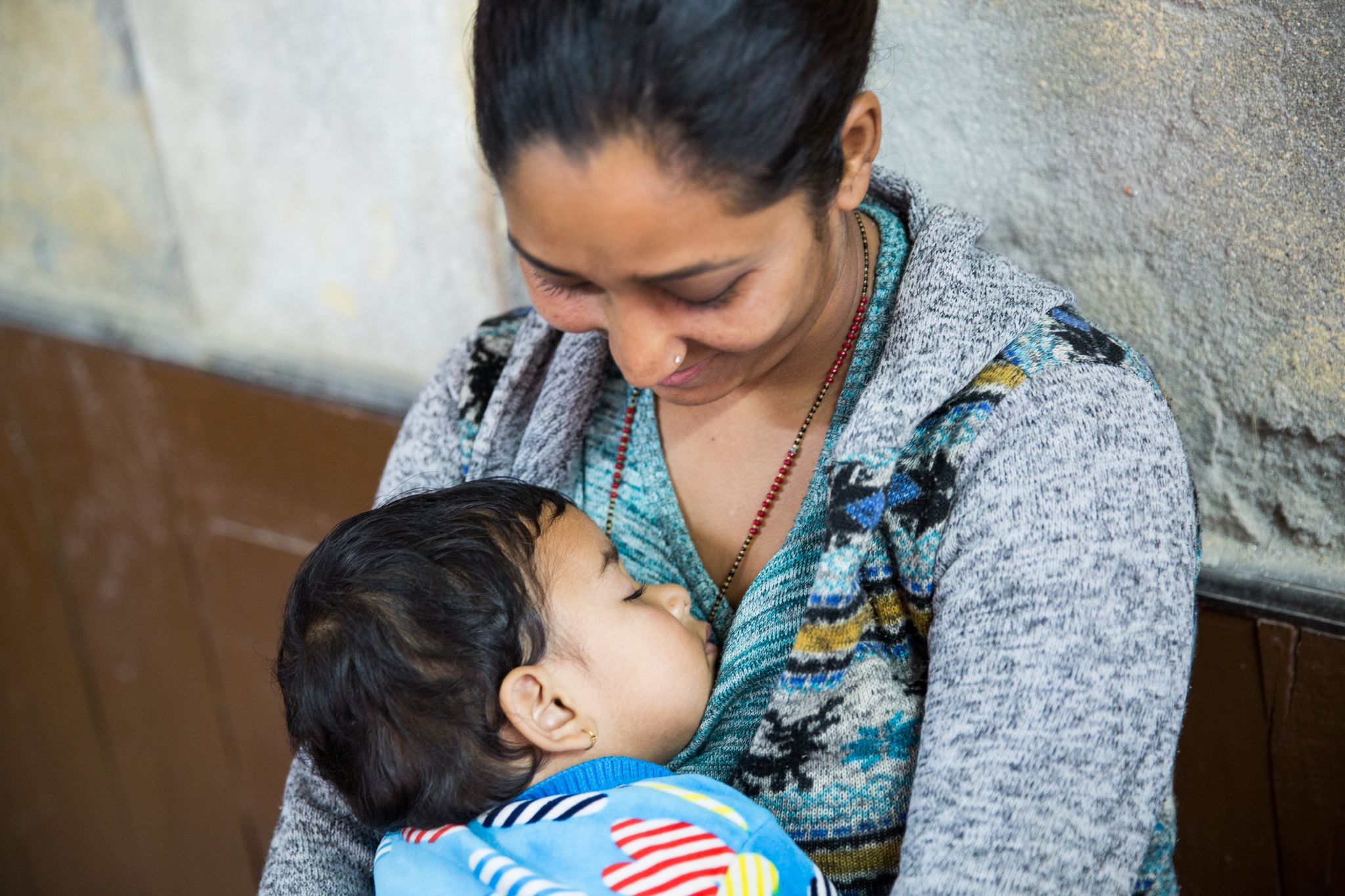 A woman looking down at her sleeping child.